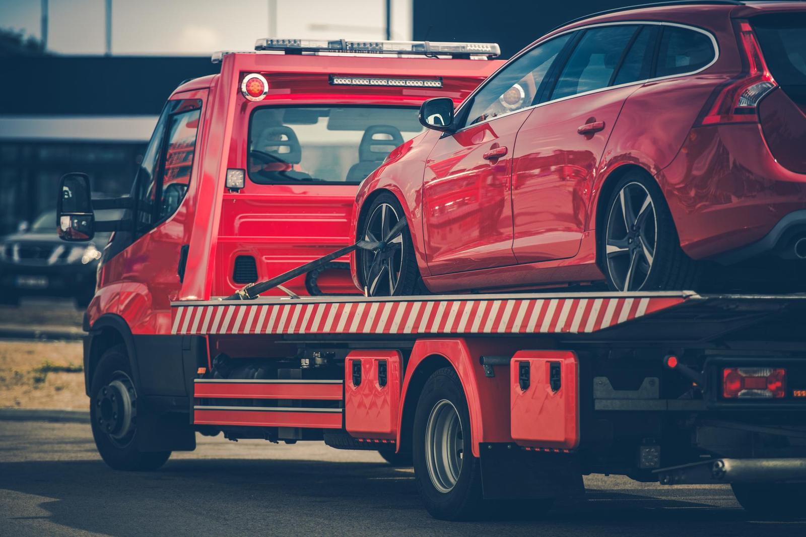 Carro attrezzi rosso che trasporta un'auto rossa