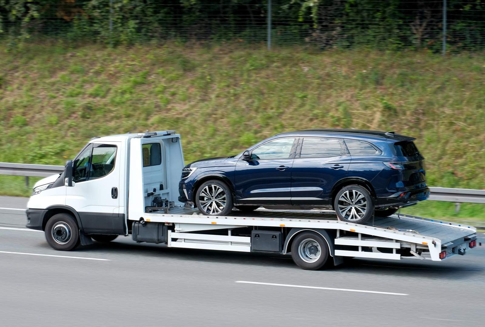 SUV blu trasportato da un carro attrezzi bianco in tangenziale